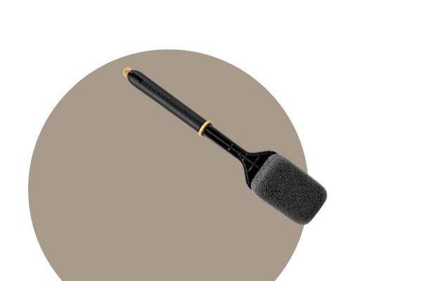 a grill sponge with a black handle