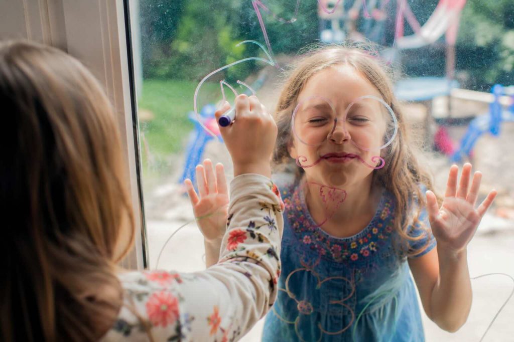 child at glass with dry erase markers
