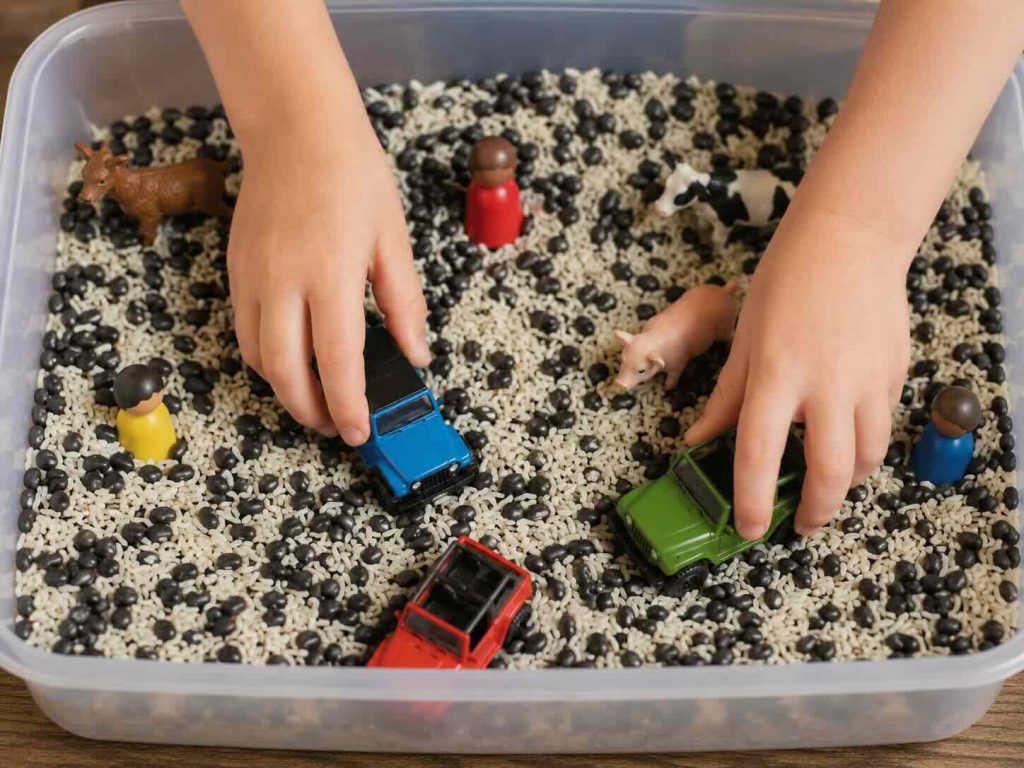 child playing in beans and rice with toys